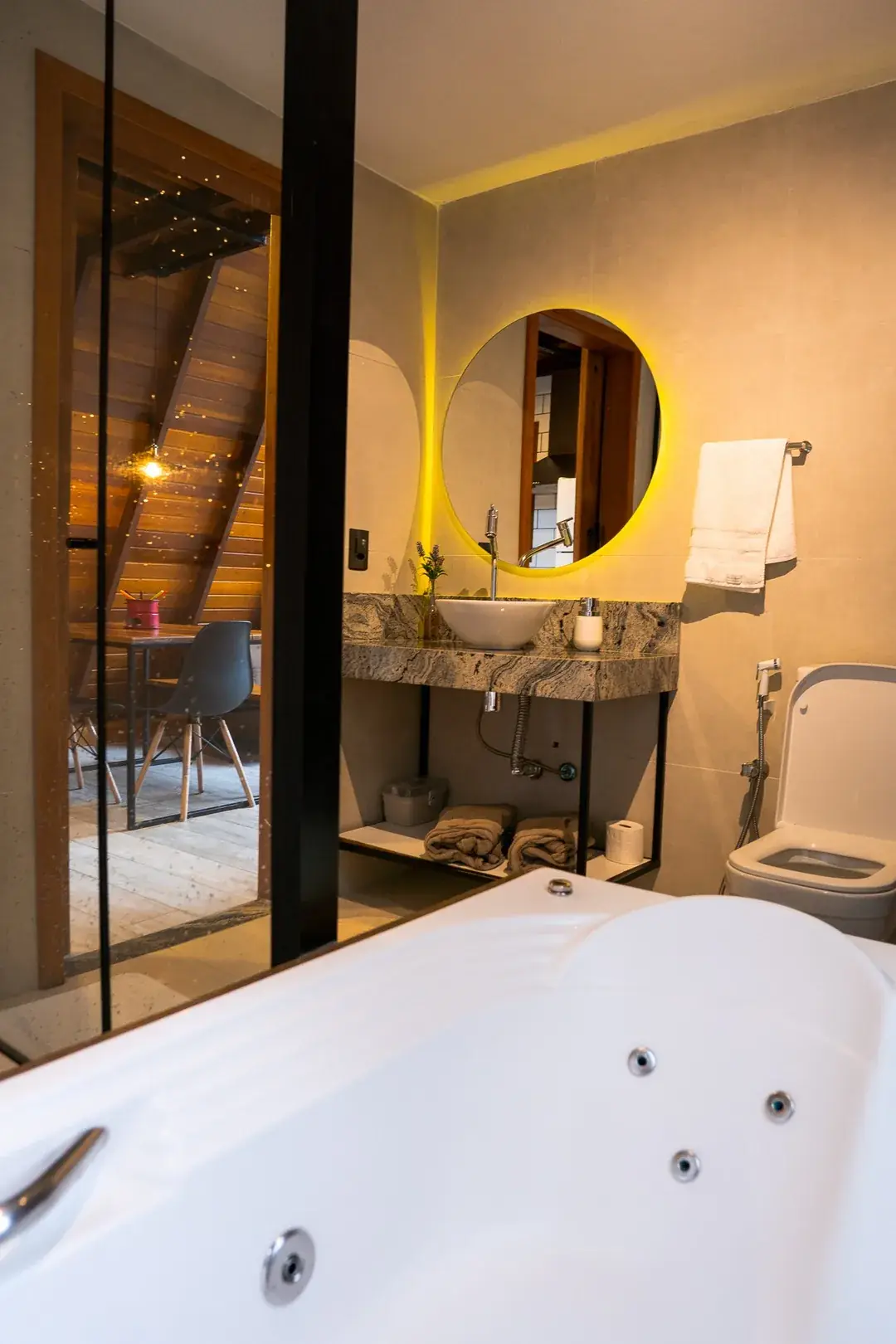 Banheiro da Solaris com hidromassagem dupla, espelho redondo iluminado e granito