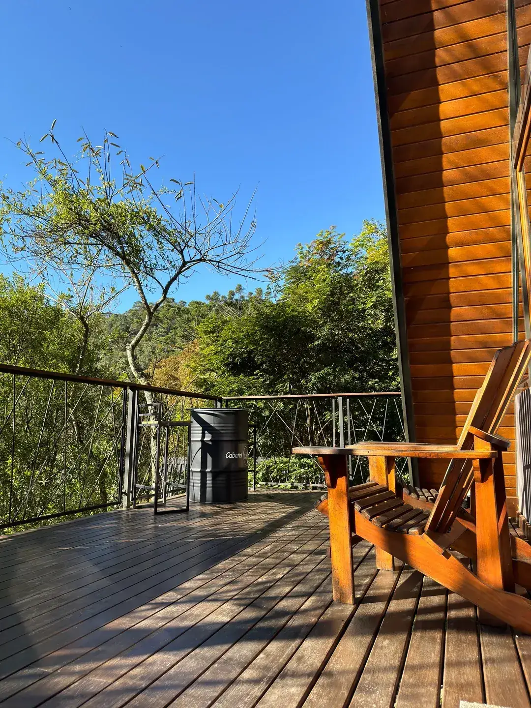 Deck de madeira ao sol com vista aberta para as montanhas do Vale da Gávea